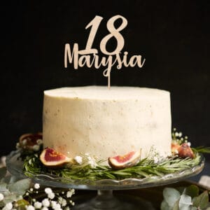 vertical shot of a white happy birthday dream cake with green leaves at the bottom